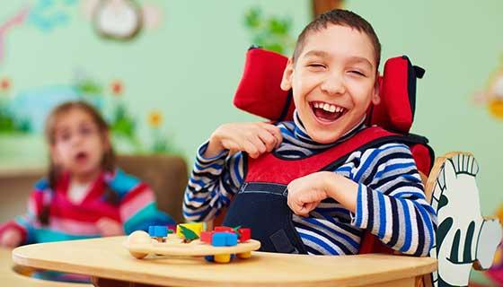 A young boy with cerebral palsy smiles.